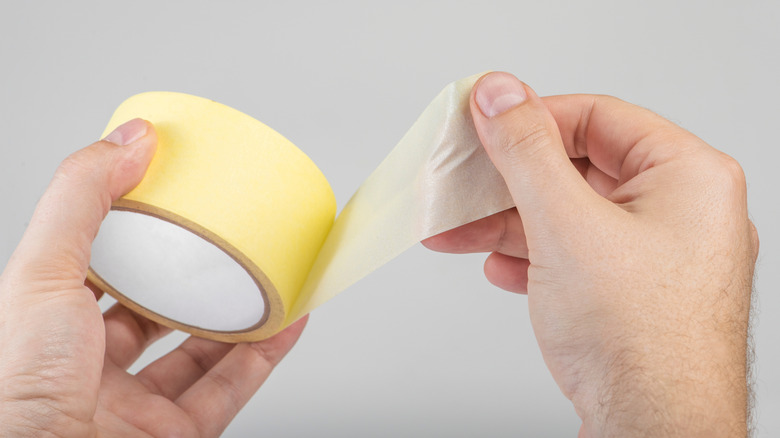 Hands taking tape out from roll