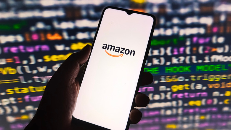 Amazon logo on phone with coding background