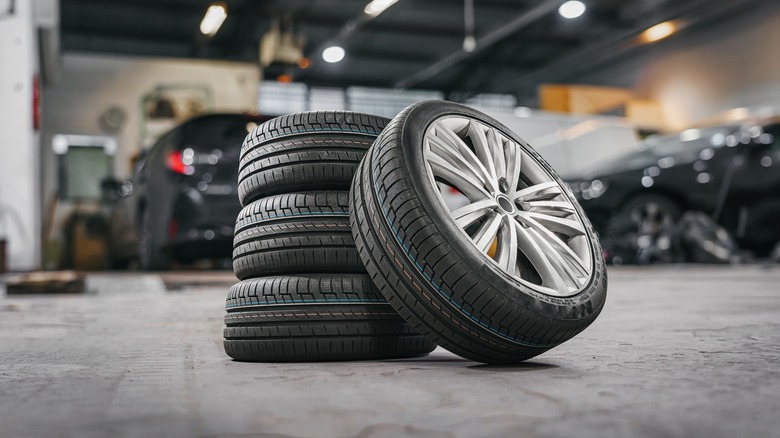 A stack of four tires in the middle of a car garage