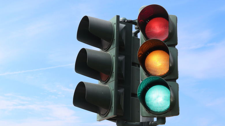 Close up of traffic lights with all three lights illuminated.