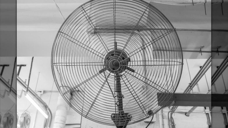 A large fan mounted to a garage wall