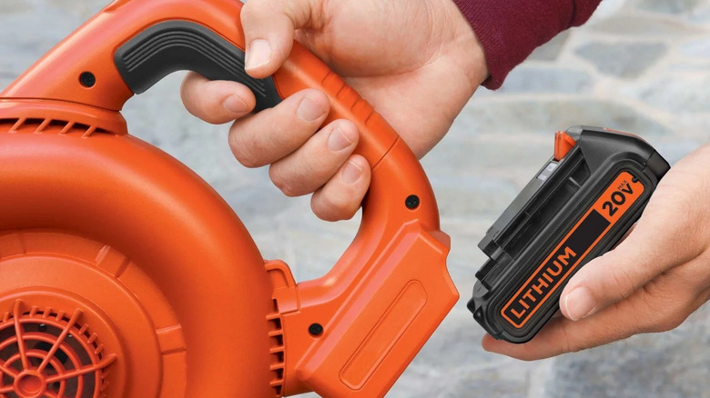Hand inserting 20V battery to power tool