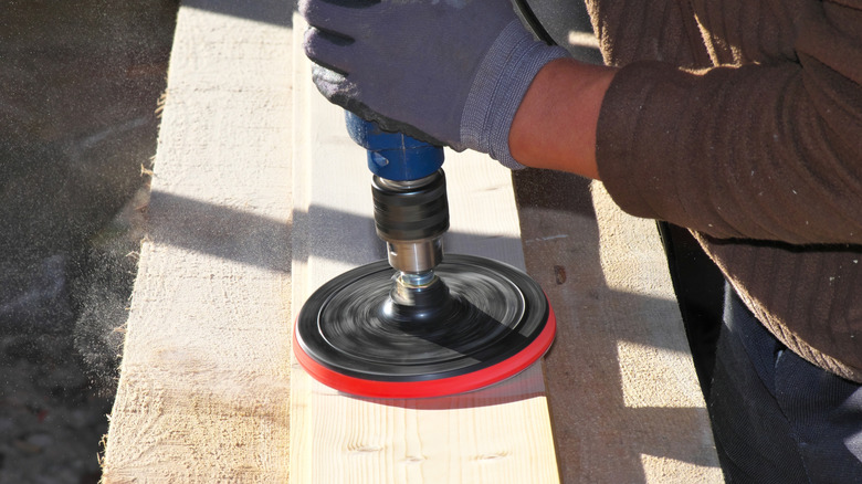 Person using drill to sand wood