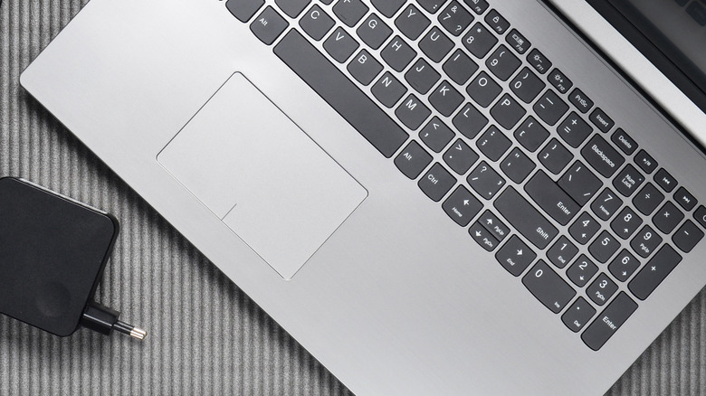 Open laptop with charger besides it