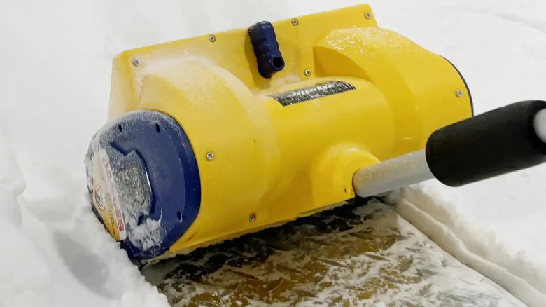 A Mellif cordless snow shovel picking up snow.