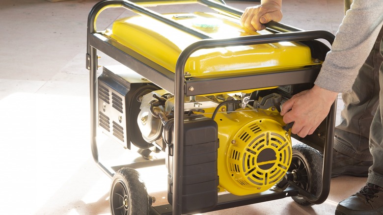 Person touching a yellow portable generator