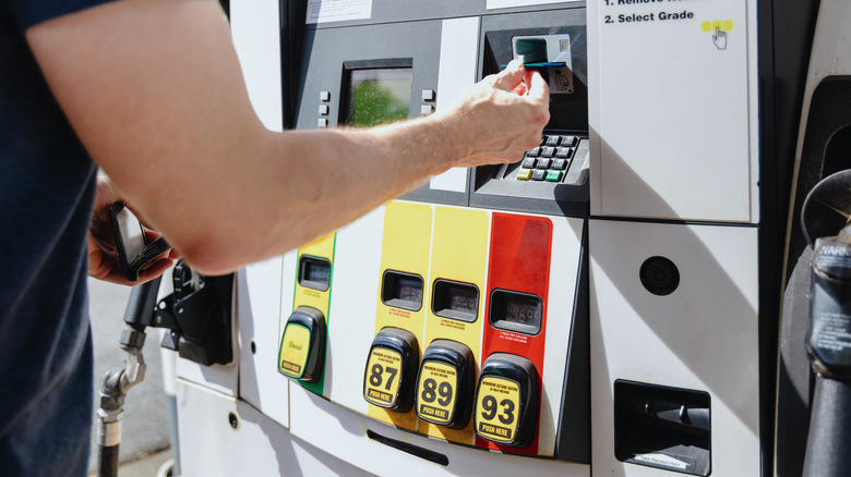 Man at gasoline pump paying with card
