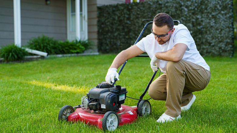 Man checking oil level of lawn mower