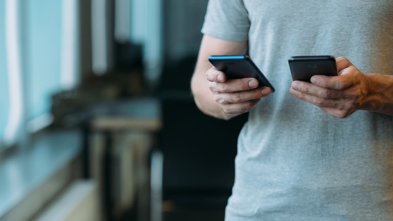 Man holding two smartphones
