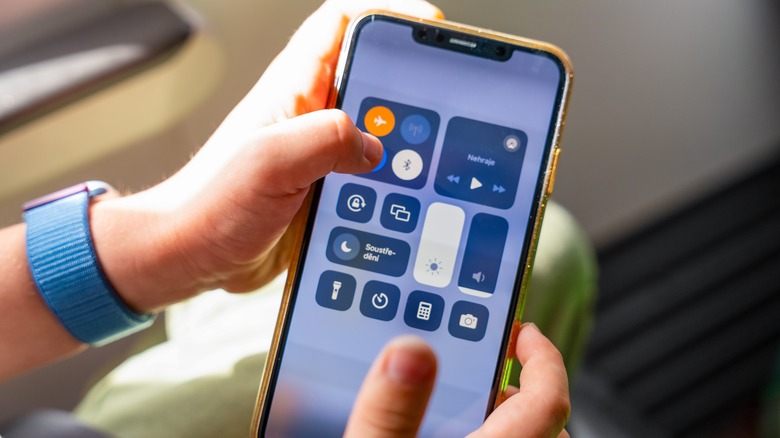A person activating airplane mode while seated on a plane