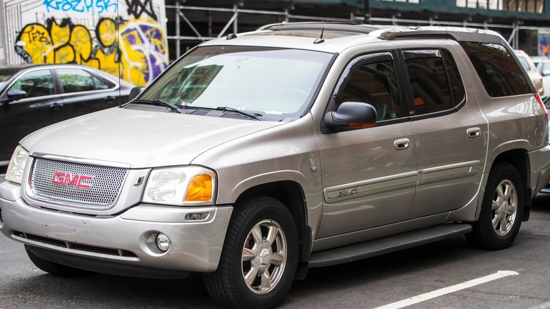 2006 GMC Envoy parked next to a graffiti wall