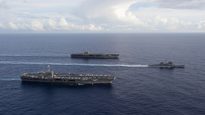 Two U.S. carriers and a destroyer sailing in formation