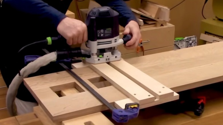 Person using a dado jig to cut a dado using a router