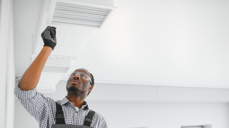 A man checking a ventilation system