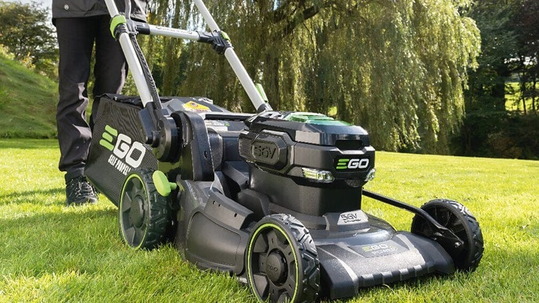 A person trimming a yard with an Ego Lawn Mower