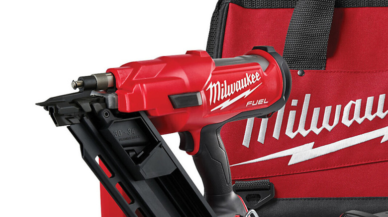 A close up of a Milwaukee framing nailer and a battery