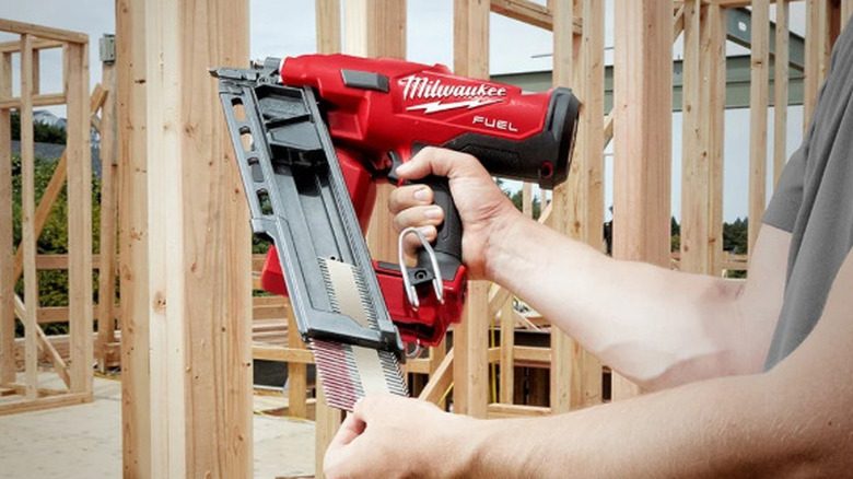 A man using a Milwaukee framing nailer