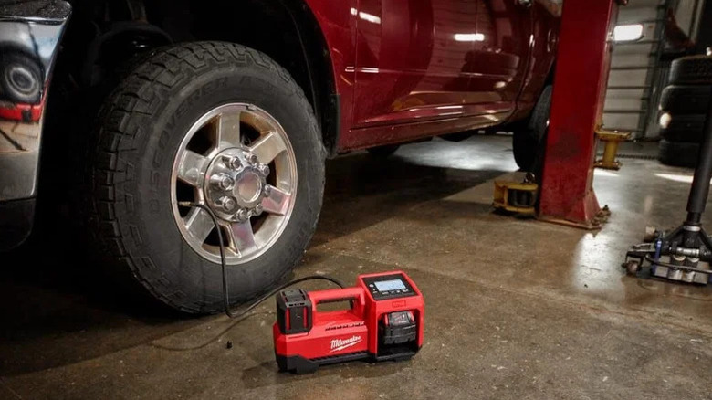 M18 Cordless Tire Inflator next to car