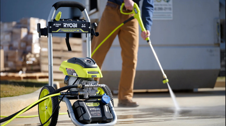 A man using a Ryobi pressure washer to clean
