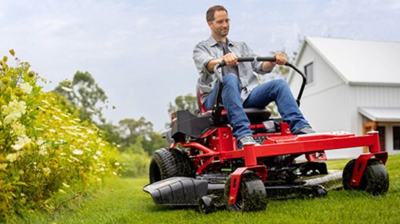 Mowing near the edge of a flower plot with a Troy-Bilt zero-turn lawn mower.
