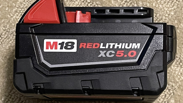 A Milwaukee M18 battery on its side.