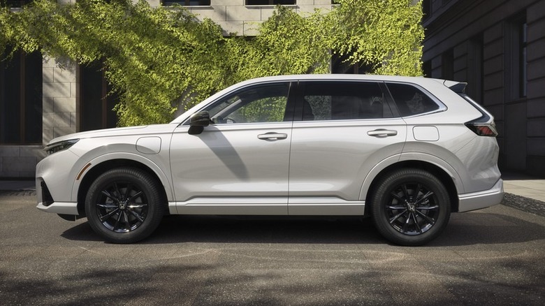 White Honda CR-V Hybrid parked near a building covered in ivy