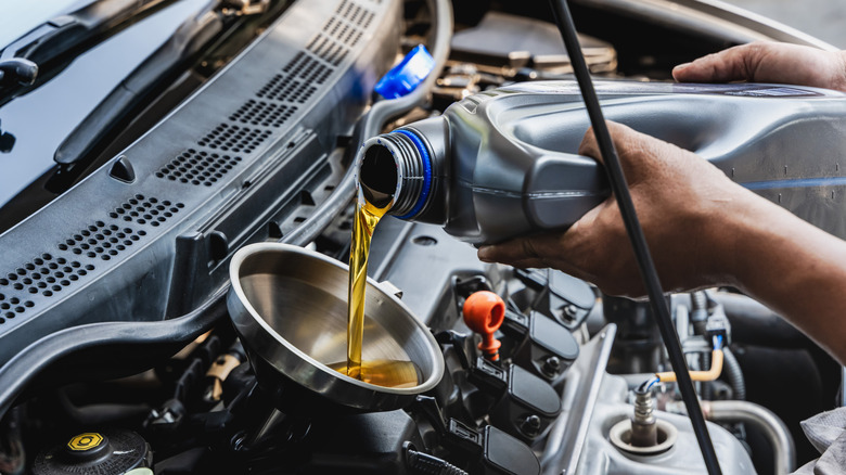 A car owner pouring in new oil