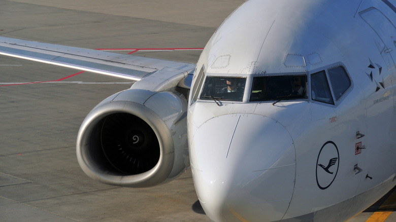 A close-up of a commercial airplane cockpit with a pilot inside