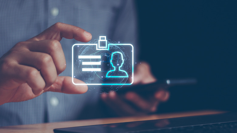 A close-up of a hand holding an illustration of a digital ID concept