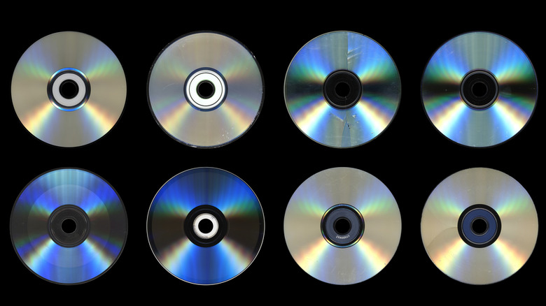 CDs, DVDs, and Blu-ray discs laying down.