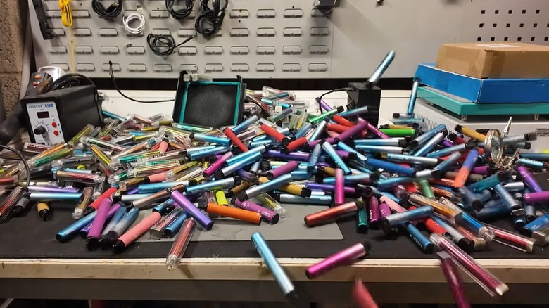 Dozens of used vapes on a table.