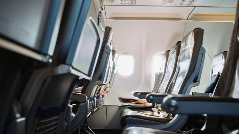 Empty seat row aboard commercial airplane, no people.