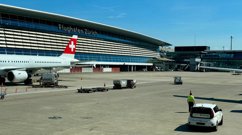 Plane from Swiss Airline parked in the slot at Zurich international airport, in front of the main ZRH building.
