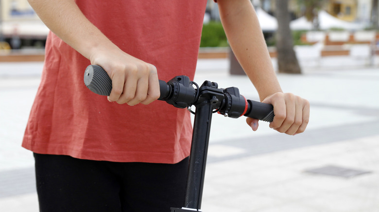 Hands on handlebar of scooter, close-up