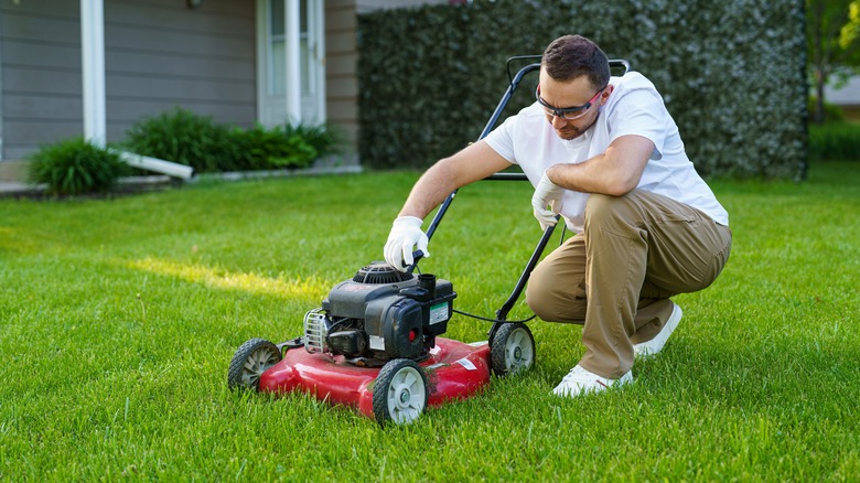 Person operating a small lawn mower in his backyard