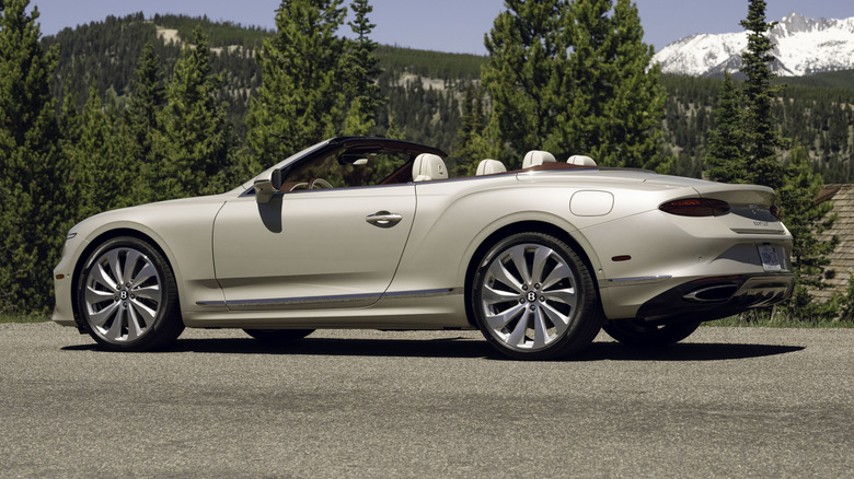 A rear quarter view of a white Bentley Continental GTC parked in nature