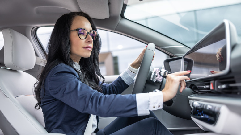 Businesswoman in suit manipulating a car's infotainment display