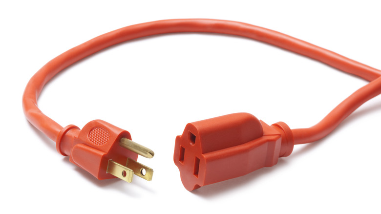 Orange extension cord plug and receptacle on white background