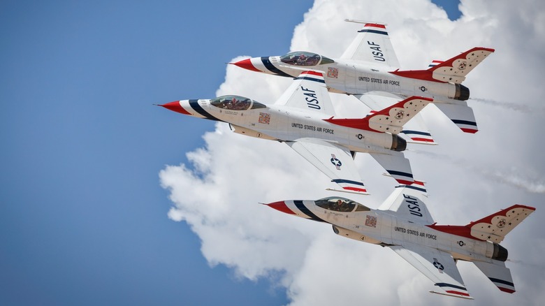 Three U.S. Air Force Thunderbird F-16 jets flying in a triangle formation with red, white, and blue livery