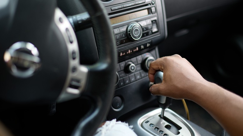 Driver changes gear in car
