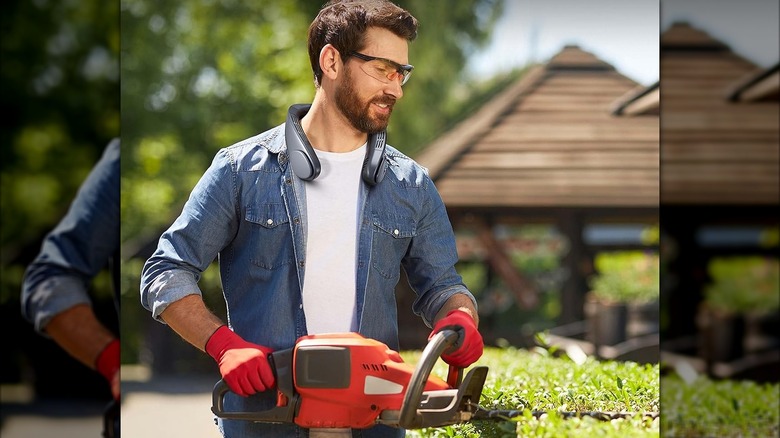 A man doing yard work with a neck fan