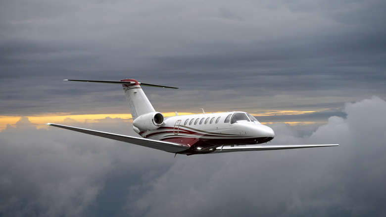 Private jet flying above the clouds