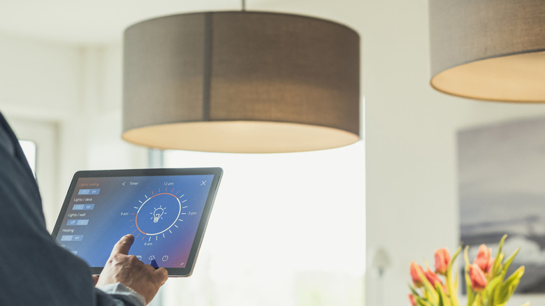 Person using an app on a tablet to control smart bulb