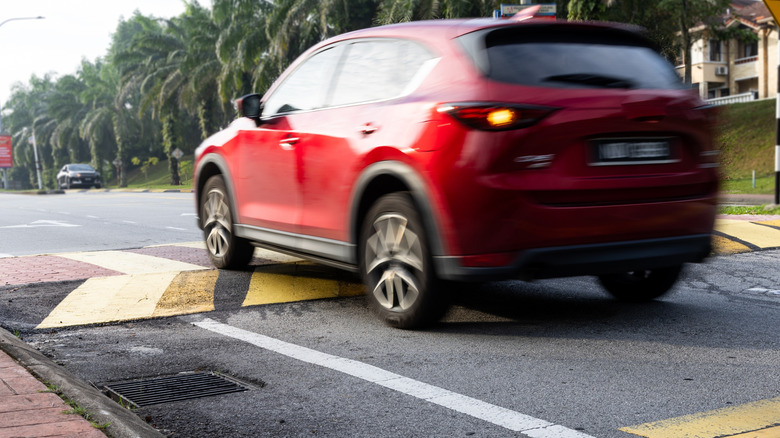 Motion-blurred Car driving over a speed hump too fast