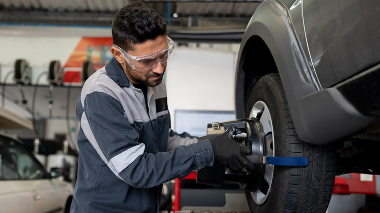 A mechanic using a device to check tire balancing