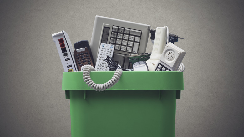 Several pieces of gadgets in a trash can.