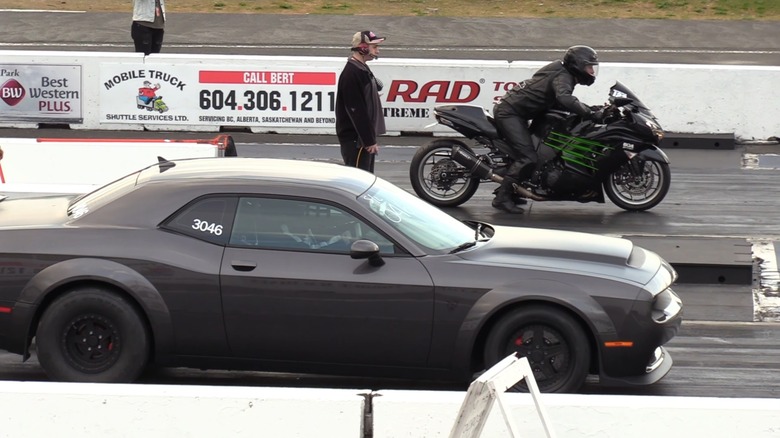 Dodge Demon 170 staging against Kawasaki Ninja ZX-14 at drag race, right-side view