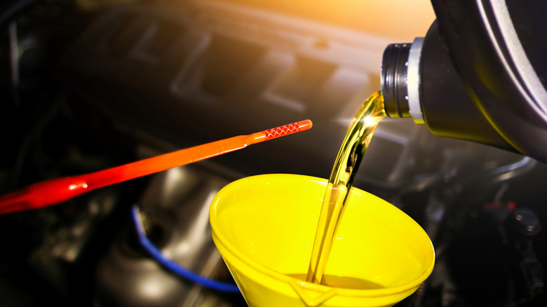 Pouring fresh oil into an engine with funnel