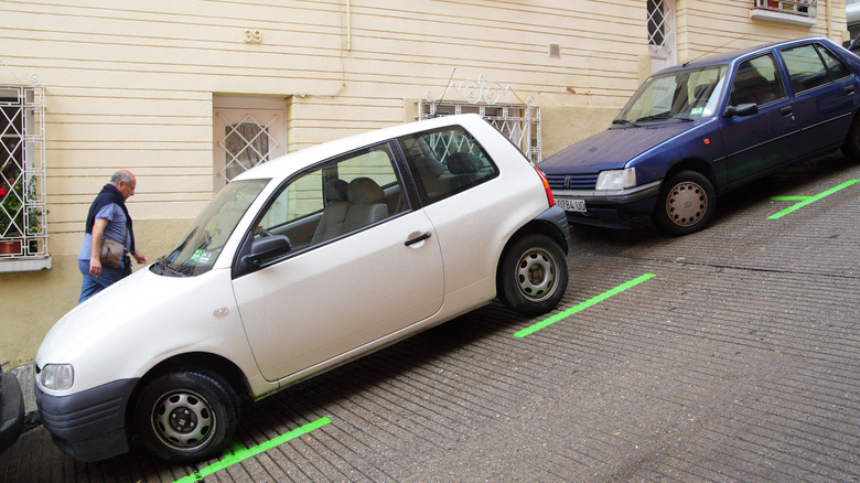 White and blue car parked on steep hill