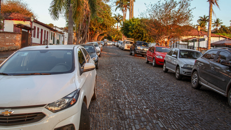 Cars parked on hill during sunset